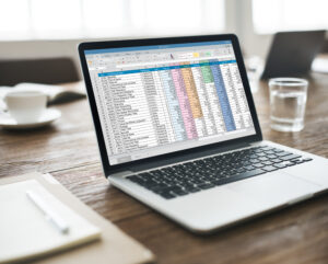 Laptop na biurku i excel na ekranie.
